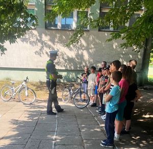 policjant ruchu drogowego przeprowadza pogadankę z uczniami.