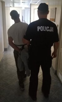 policjant z zatrzymanym na korytarzu komendy