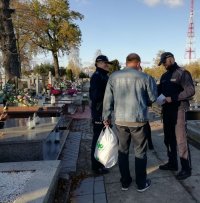 dzielnicowi rozdają ulotki na cmentarzu.