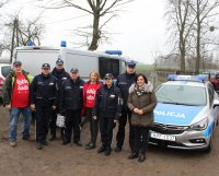 akcja Szlachetna Paczka, pamiątkowe zdjęcie wolontariuszy z policjantami i pracownikami, w tle radiowóz.