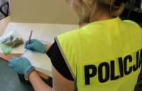 zabezpieczone narkotyki przez policjantów oraz policjant w kamizelce z napisem POLICJA.