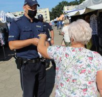 policjanci rozdają maseczki.