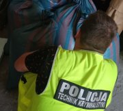 policjant w kamizelce z napisem POLICJA zabezpiecza tytoń.