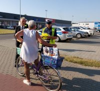 policjanci oraz burmistrz rozdają kamizelki odblaskowe.