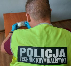 policjant wykonuje oględziny zabezpieczonej amfetaminy.