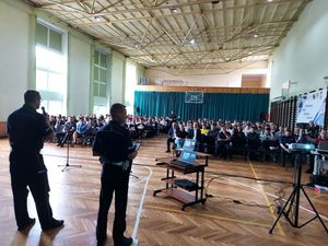 III KONFERENCJA MŁODY BEZPIECZNY KIEROWCA W ŁOWICZU, widok uczniów na sali, policjanci stoją tyłem.