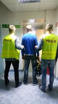 Policjanci prowadzą zatrzymanego