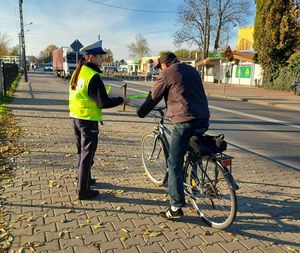 policjanci z ruchu drogowego rozdają odblaski.