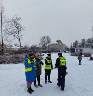 uczestnicy parkrun Łowicz z odblaskami oraz policjanci ruchu drogowego.