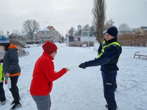 uczestnicy parkrun Łowicz z odblaskami oraz policjanci ruchu drogowego.