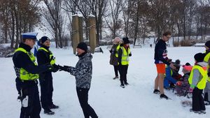 uczestnicy parkrun Łowicz z odblaskami oraz policjanci ruchu drogowego.