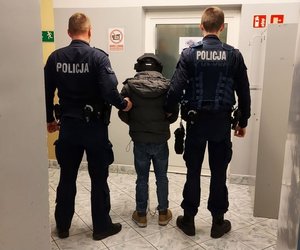 policjanci prowadzą zatrzymanego.