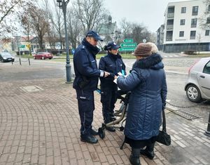 dzielnicowi rozdają ulotki i odblaski.