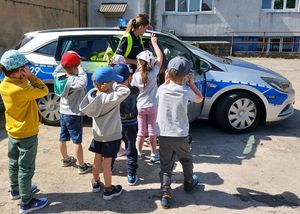 policjantka z dziećmi przy radiowozie.