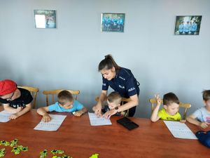policjantka z dziećmi robi odciski palców.
