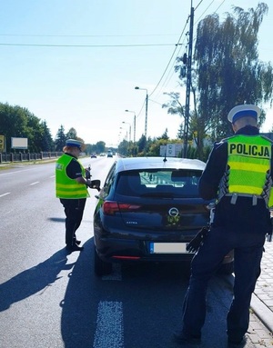 policjanci ruchu drogowego kontrolują pojazd.