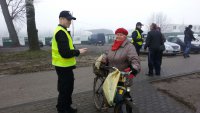 policjanci rozdają elementy odblaskowe