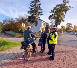 policjantki z burmistrzem rozdają opaski i zawieszki.