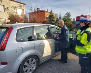 policjantki z burmistrzem rozdają opaski i zawieszki.