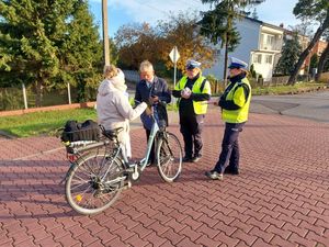 policjantki z burmistrzem rozdają opaski i zawieszki.