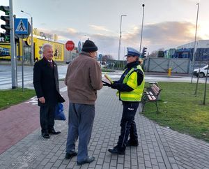 policjanci wspólnie z burmistrzem rozdają odblaski i zapachy samochodowe.