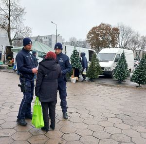 dzielnicowi rozdają ulotki na targowicy.