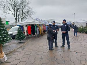 dzielnicowi rozdają ulotki na targowicy.