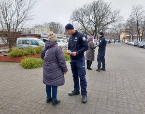 dzielnicowi rozdają ulotki na targowicy.