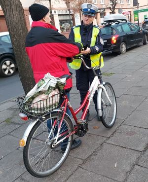 policjantka rozdaje odblaski rowerzyście.