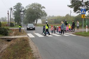 policjanci przeprowadzają przez przejście dla pieszych dzieci.