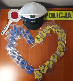 czapka policjanta ruchu drogowego oraz serduszka z napisem : Zwolnij! Jak kocha to poczeka.