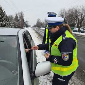 policjantka przekazuje serce z napisem zwolnij kierującemu.