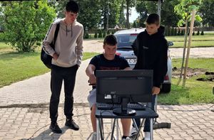 uczniowie przy symulatorze jazd motocyklem.