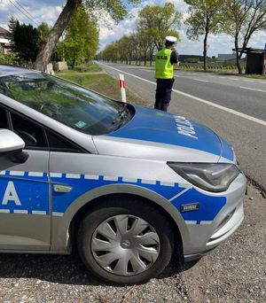 policjant kontroluje prędkość pojazdów na drodze.