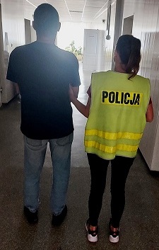 policjant prowadzi zatrzymanego