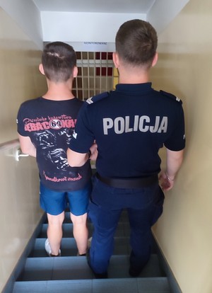 policjant prowadzi zatrzymanego
