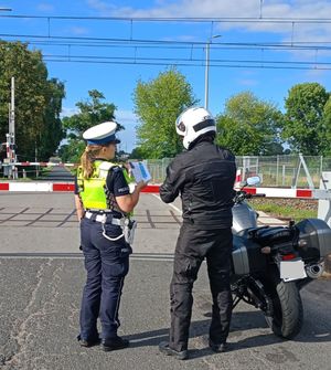 policjantka wręcza ulotkę motocykliście.