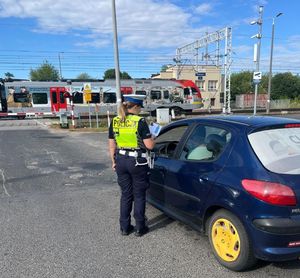 policjantka wręcza ulotkę kierującemu pojazdem.