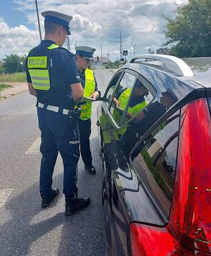 policjanci wręczają ulotki kierującym.