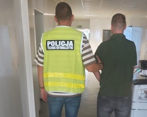 Technik kryminalistyki prowadzi zatrzymanego