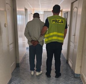 nieumundurowany policjant prowadzi zatrzymanego.