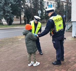 policjanci rozdają odblaski.