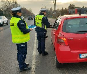 policjanci rozdają ulotki.
