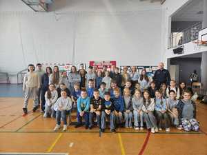 zdjęcie grupowe policjanta z uczniami i nauczycielami .