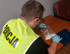policjant z zabezpieczonymi narkotykami.