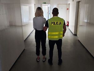 policjant prowadzi zatrzymaną.