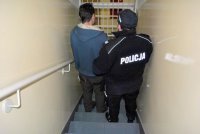 Policjanci prowadzą zatrzymanego