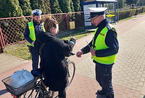 policjanci rozdają elementy odblaskowe.