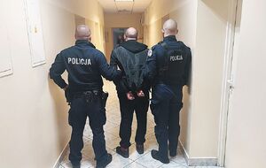 policjanci prowadzą zatrzymanego.