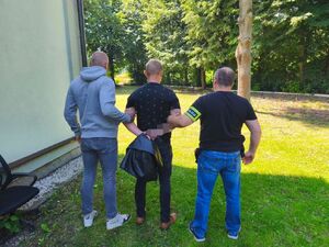 policjanciprowadzą zatrzymanego.